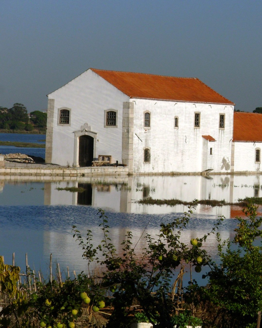 O moinho na maré cheia, com a água à volta do edifício. Fotografia de singra13 (2007, CC BY-SA 3.0), Wikimedia Commons.