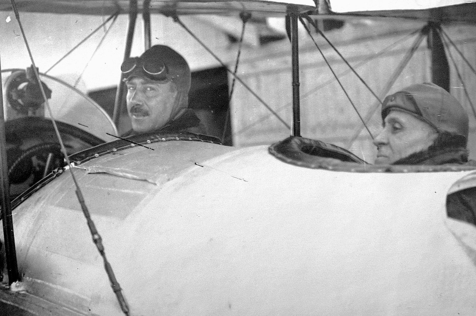 Sacadura Cabral, o piloto, à frente; Gago Coutinho, o navegador, atrás — a bordo do «Lusitânia», antes da partida. Sacadura propusera a viagem ao Ministro da Marinha em 1919; Coutinho passara décadas a medir África. (Fotografia de 1922, domínio público. Não é uma imagem gerada.)