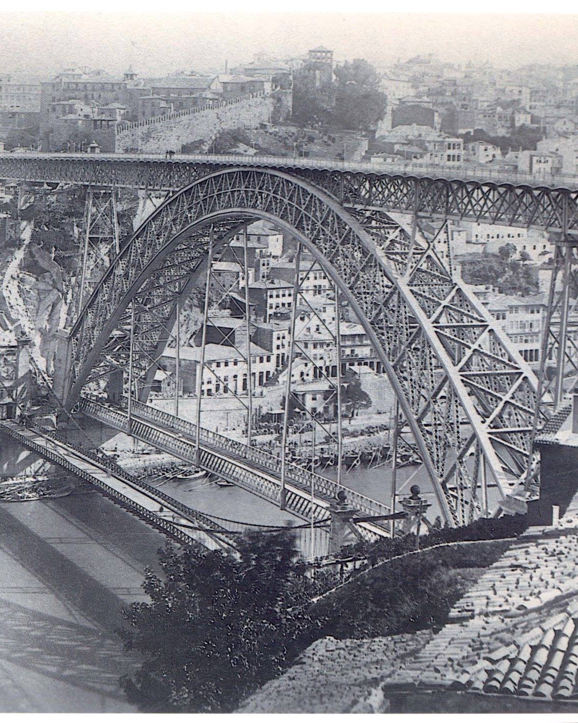 Fotografia de George Danson Tait, 1886-87. A ponte Luiz I acabada, vista do lado de Gaia, com o tabuleiro da velha ponte pênsil ainda à sua frente, à cota baixa. A pênsil viria a ser desmontada; restam dela, do lado do Porto, os dois pilares que a sustentavam.
